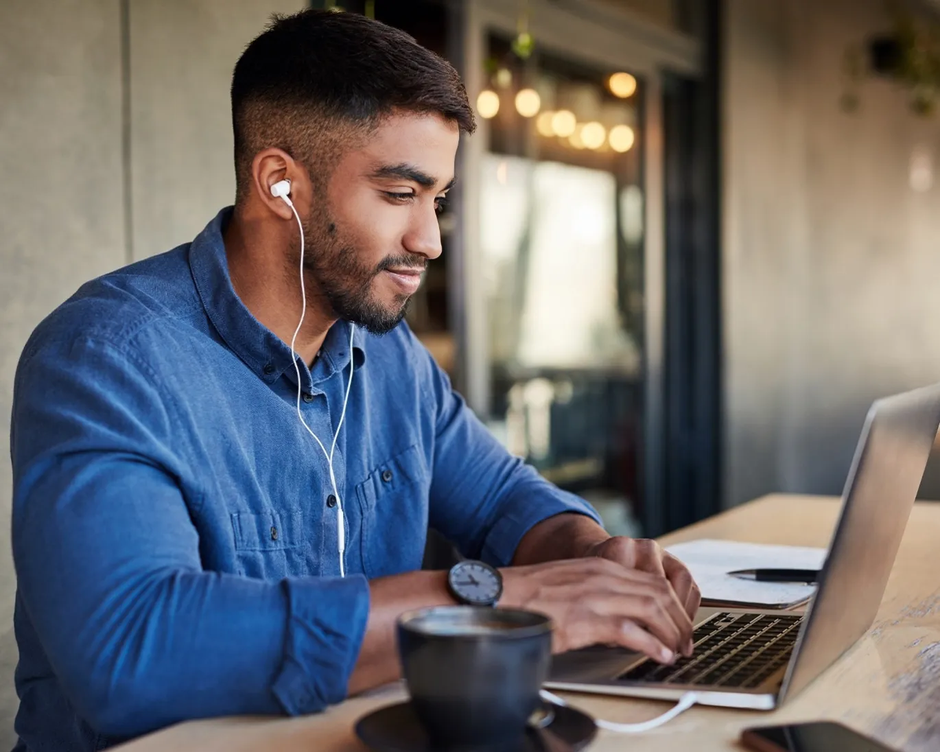 man-using-laptop-earphones-cafe