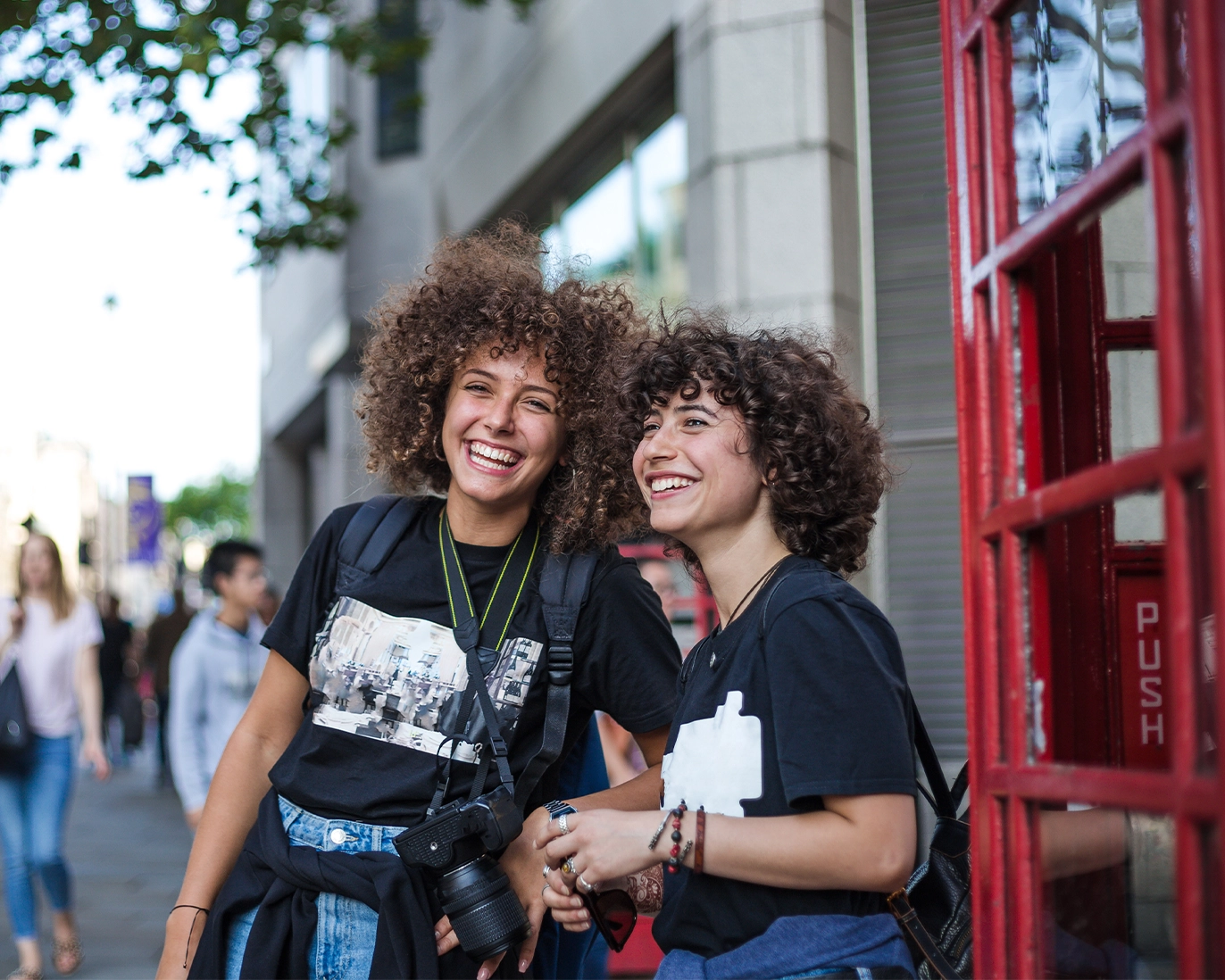 two-curly-haired-friends-city-street