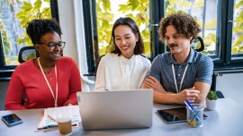 three young people working and looking at a laptop