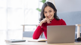 a woman looking at laptop, smiling