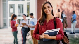 A woman smile and holds her notebooks