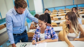 A teacher help his students in the classroom