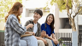Three students chat outside their school
