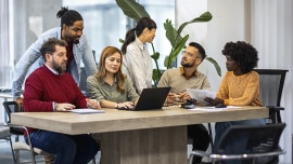 People gather around the table in a conference room