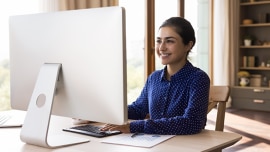 Girls reads something on a computer screen and smiles