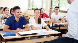Students smile and listen to their teacher in the classroom