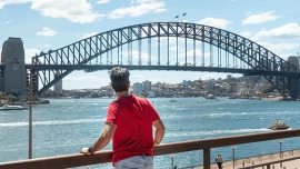 A man stands by the river and enjoys the bridge view in Sidney