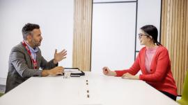 Two professionals having a conversation by the table