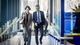a man and a woman in business clothes chatting