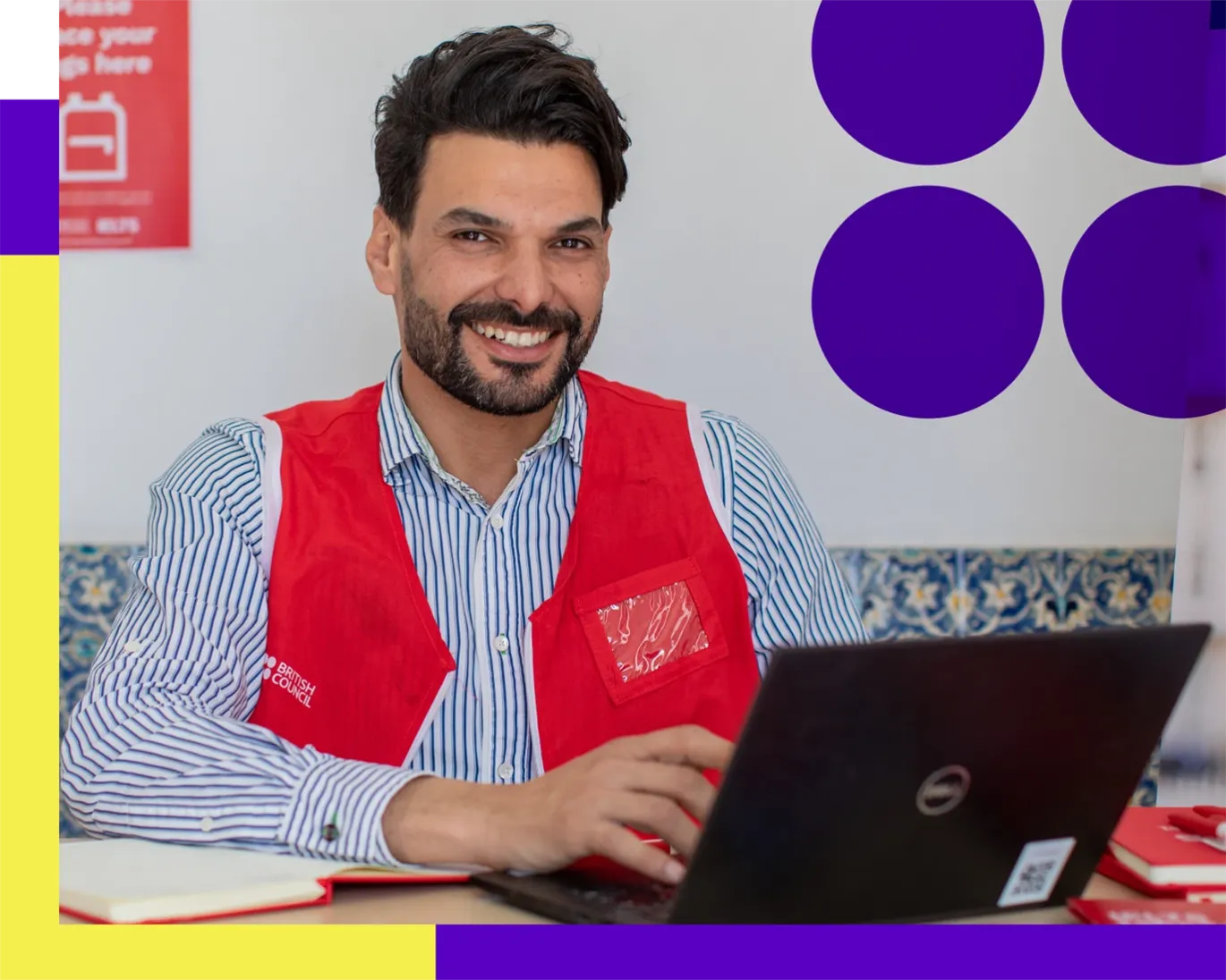 IELTS staff member assisting a test taker at the IELTS center reception desk.