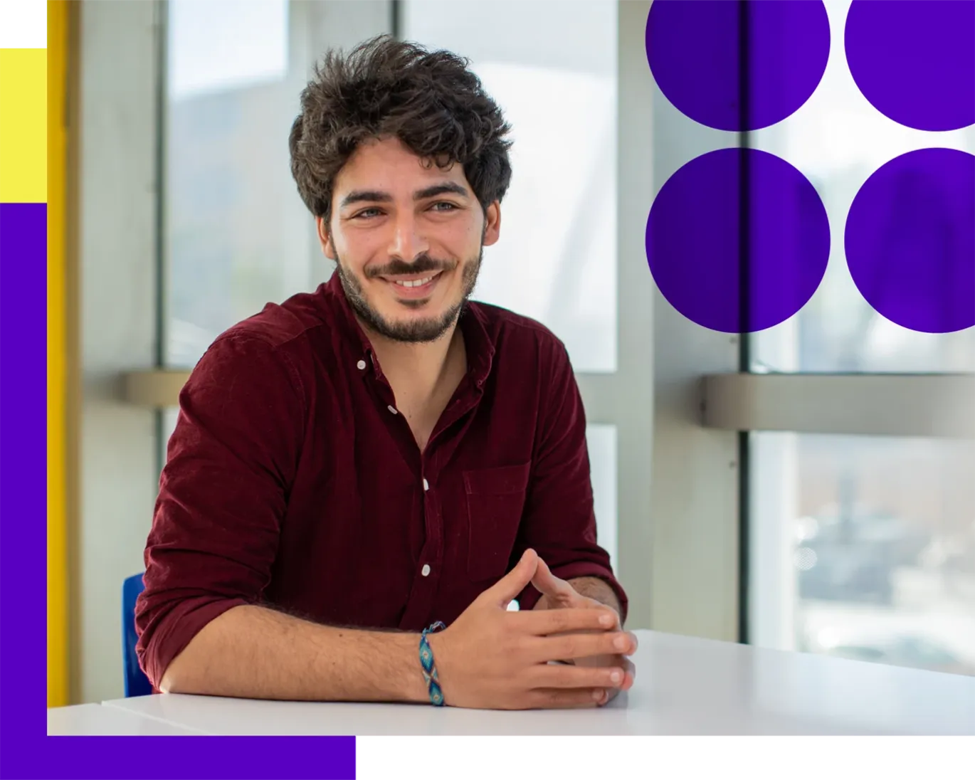 Young man smiling during a discussion session indoors.