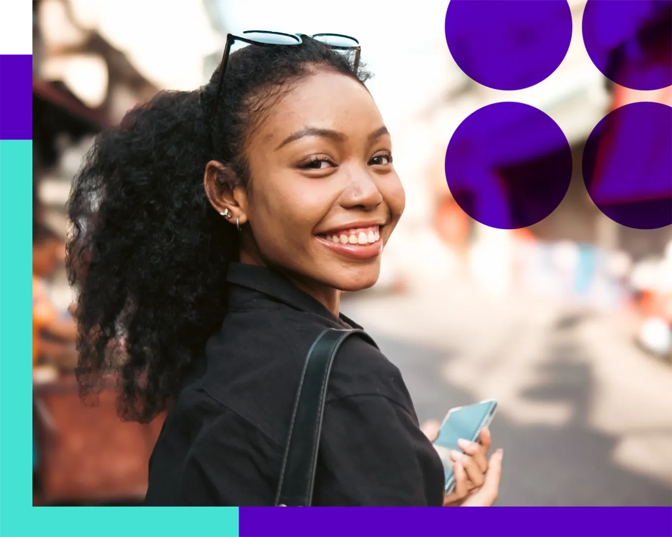 Young woman smiling while walking through a busy street market.