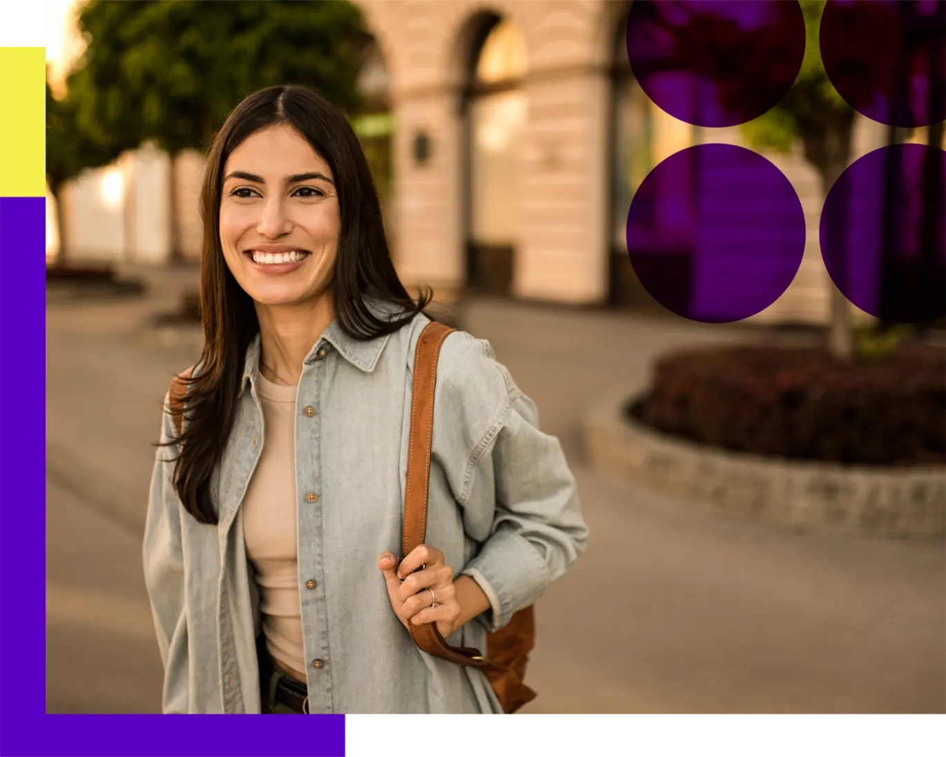 Young woman smiling outdoors with a backpack on a sunny day near campus buildings.
