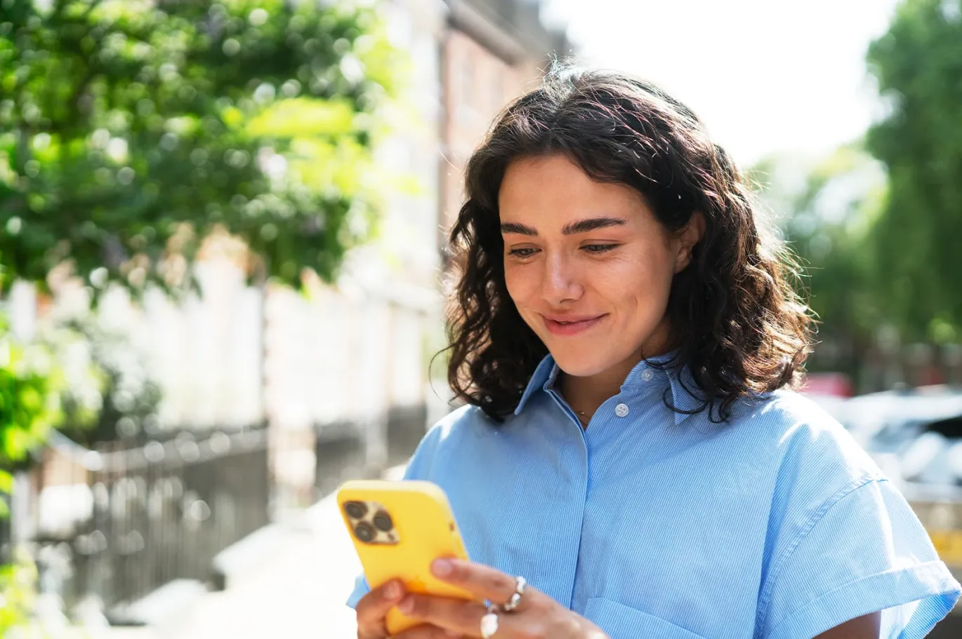 A girl smiling while using her mobile phone