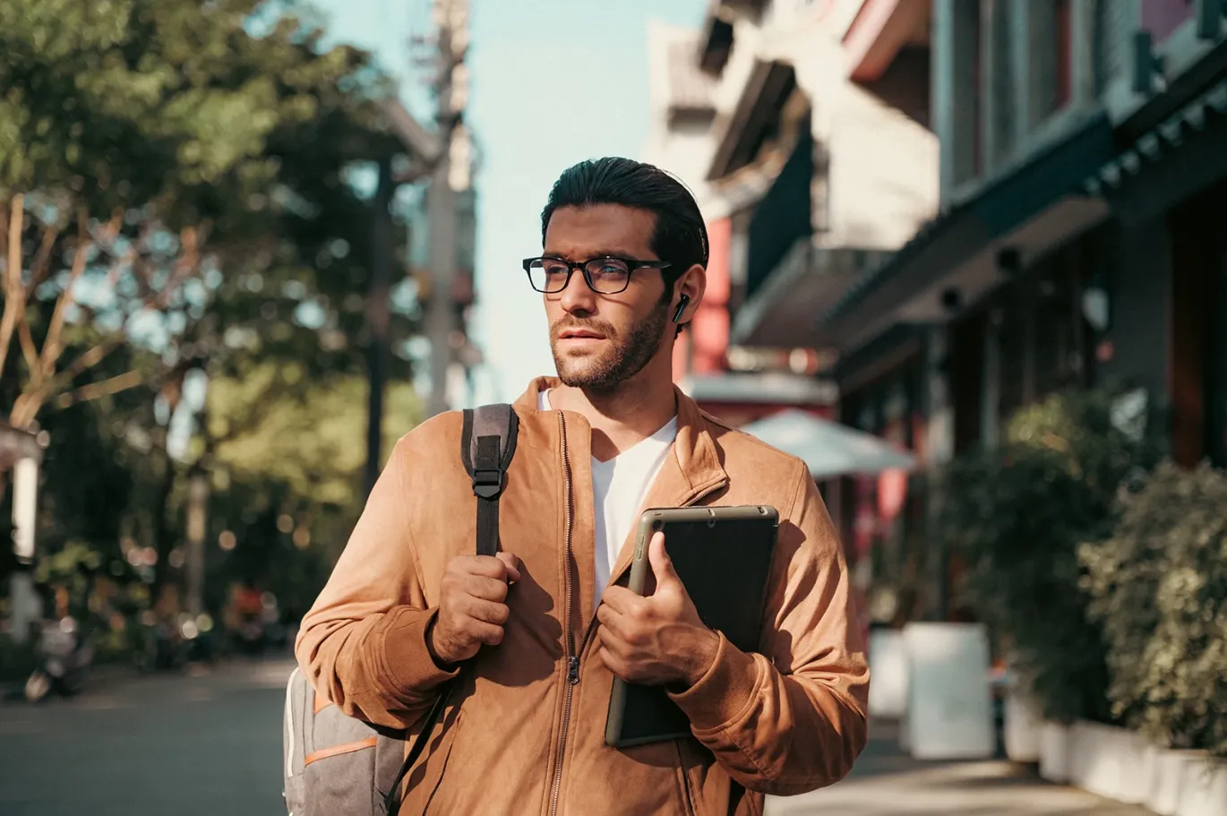 Male IELTS student carrying books and a backpack while walking near an IELTS test center