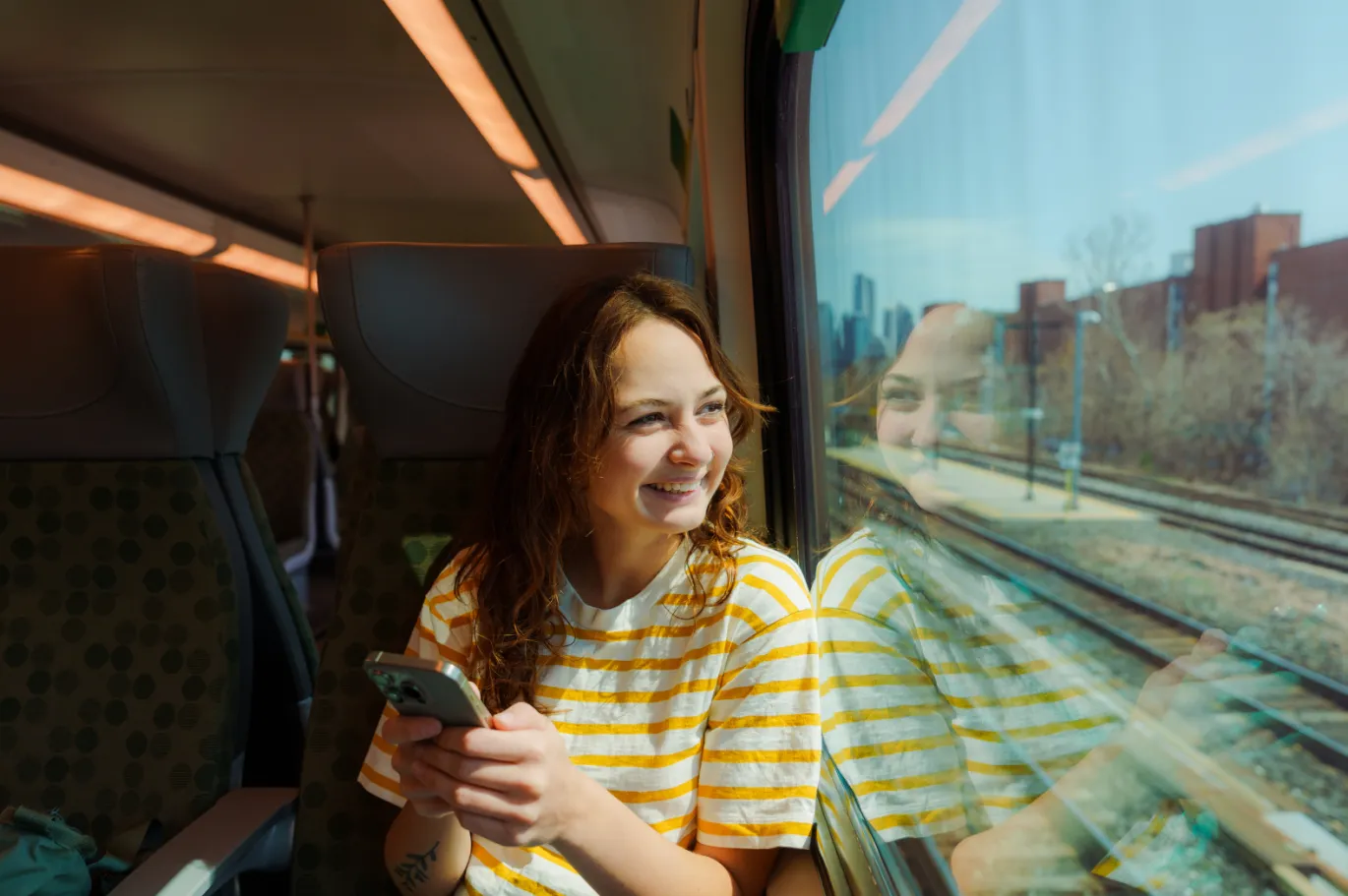 A young woman enjoying scenic view while travelling through a train