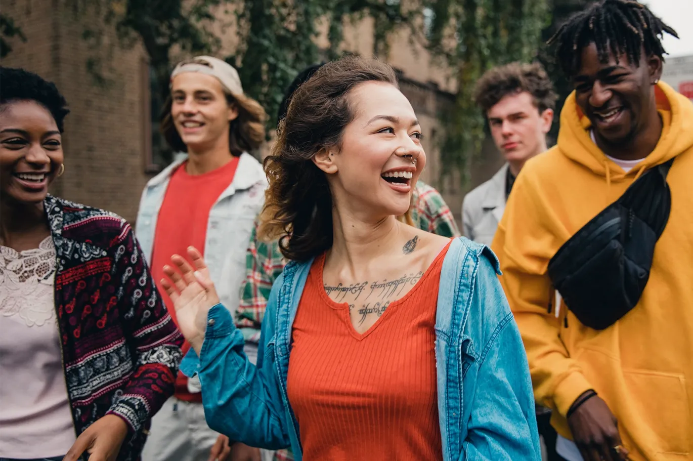 Group of friends smiling and walking together outdoors.