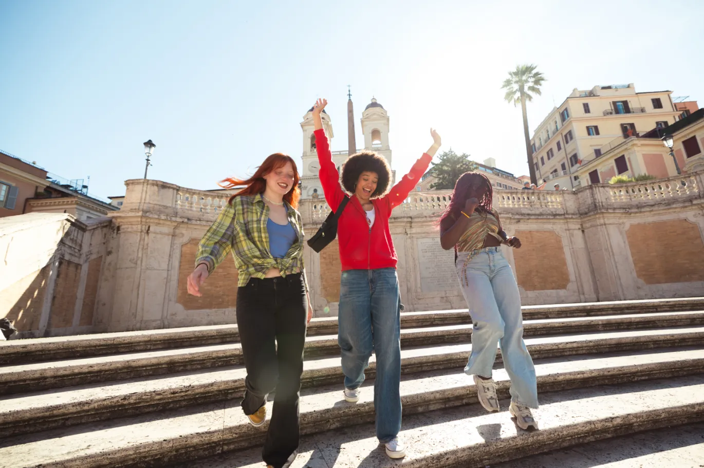 Group of friends walking down steps together in a European city.