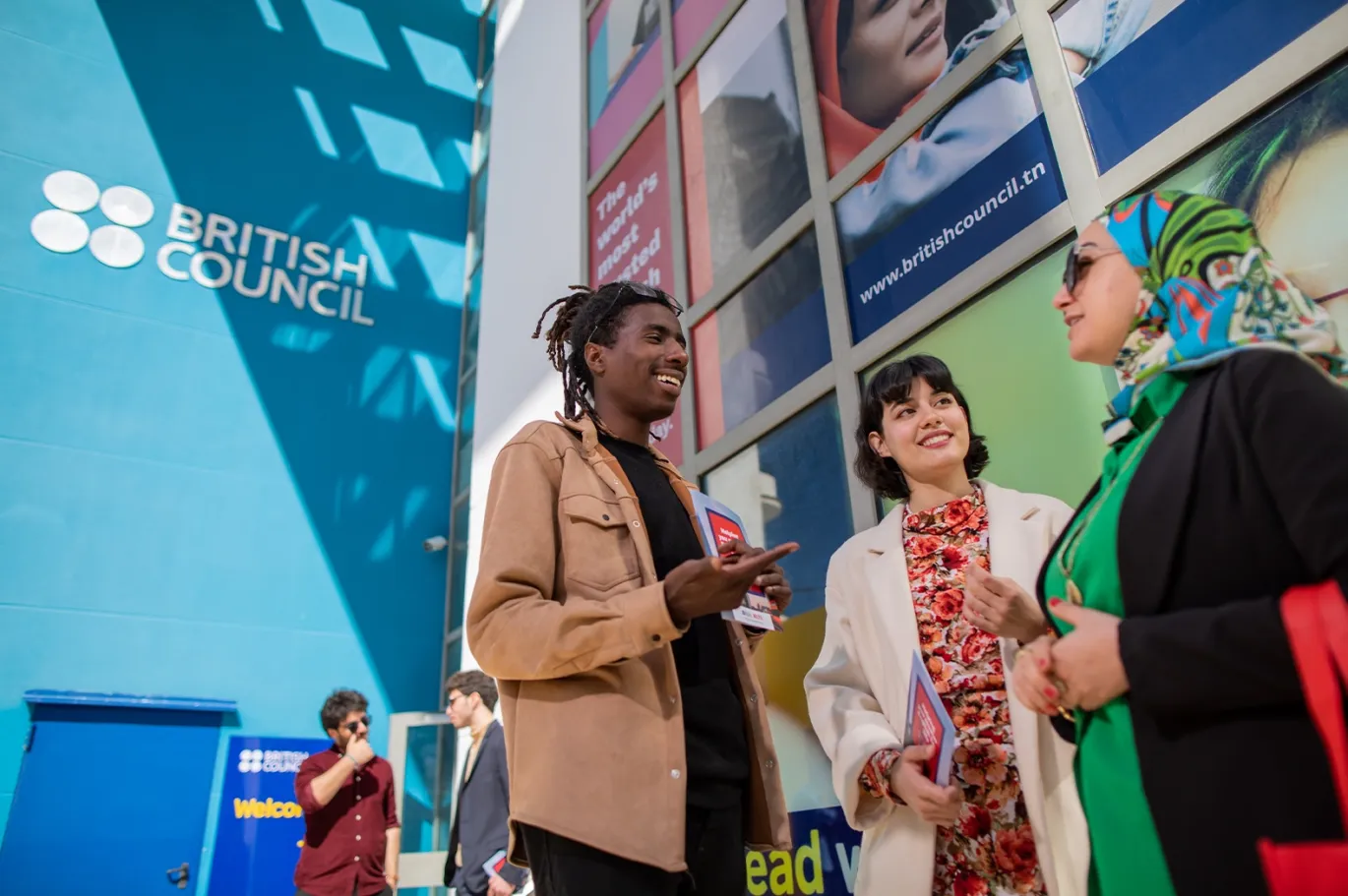 People talking together at an IELTS event or counseling center.
