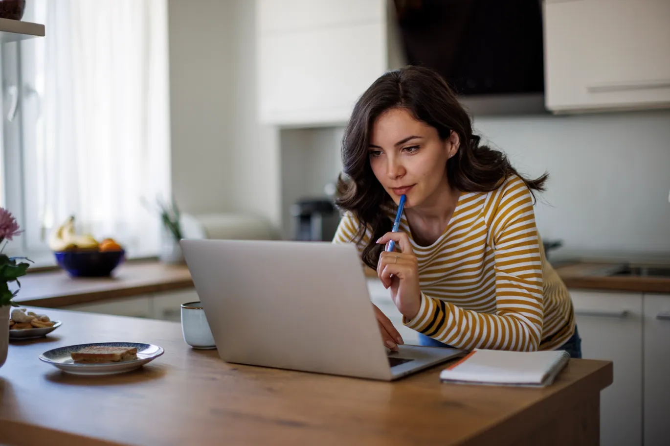 Woman studying online for the IELTS exam using a laptop at home.