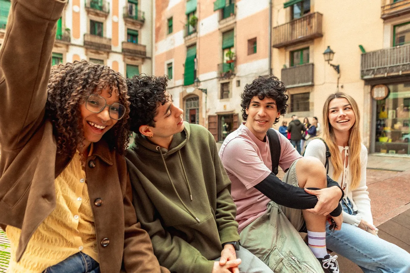 Group of friends smiling together while spending time outdoors in the city.