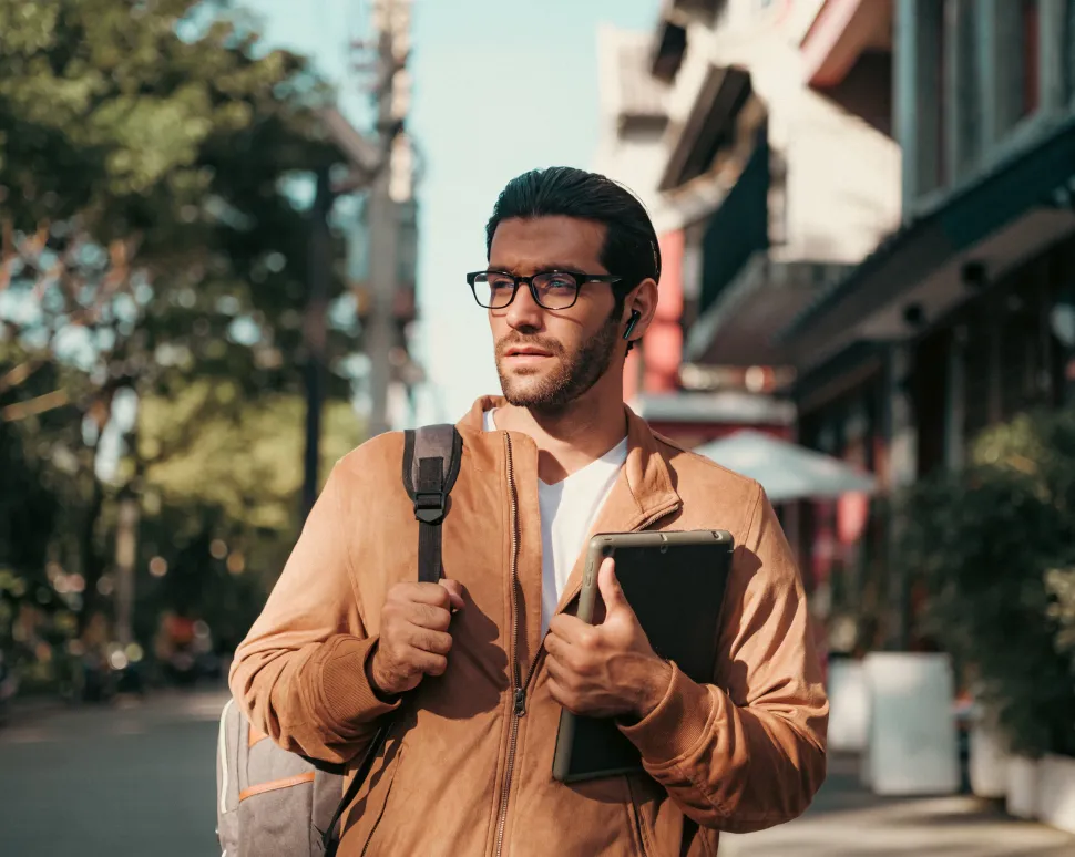 Male IELTS student carrying books and a backpack while walking near an IELTS test center
