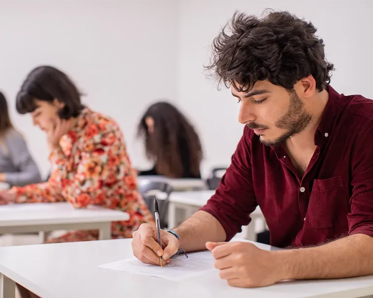 Students studying and preparing for IELTS exam while sitting in a classroom