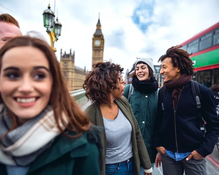 Group of friends taking a selfie together near Big Ben in London.