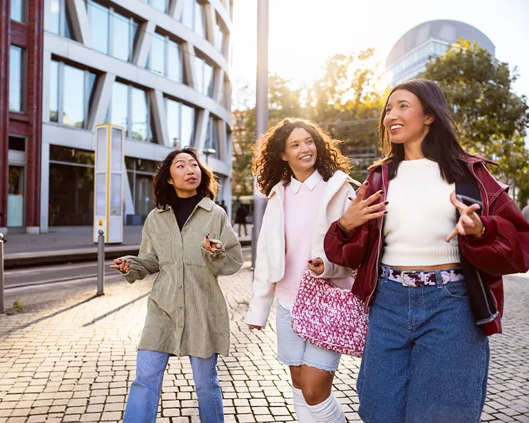 Group of friends walking together outdoors in a modern city.