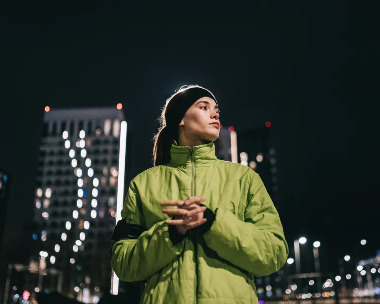 Young woman enjoying the city nightlife while standing outdoors.