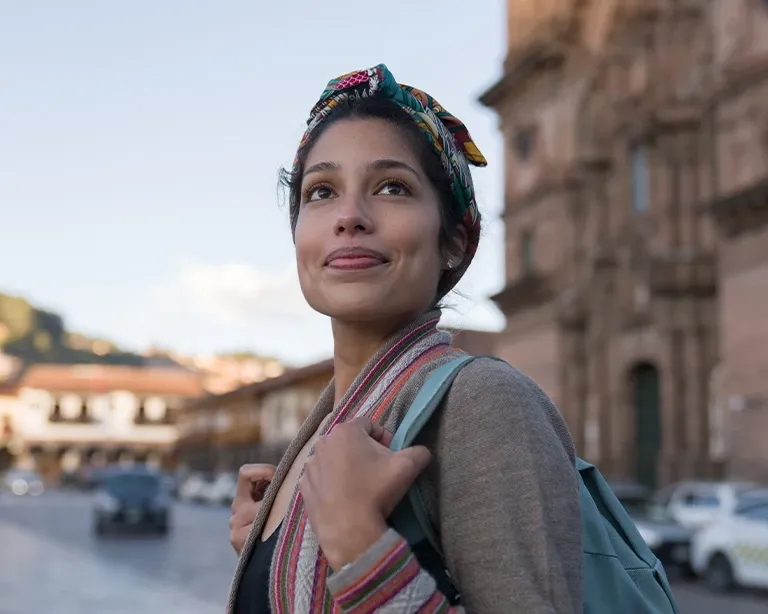Young woman with a backpack exploring a European city during her study abroad journey.