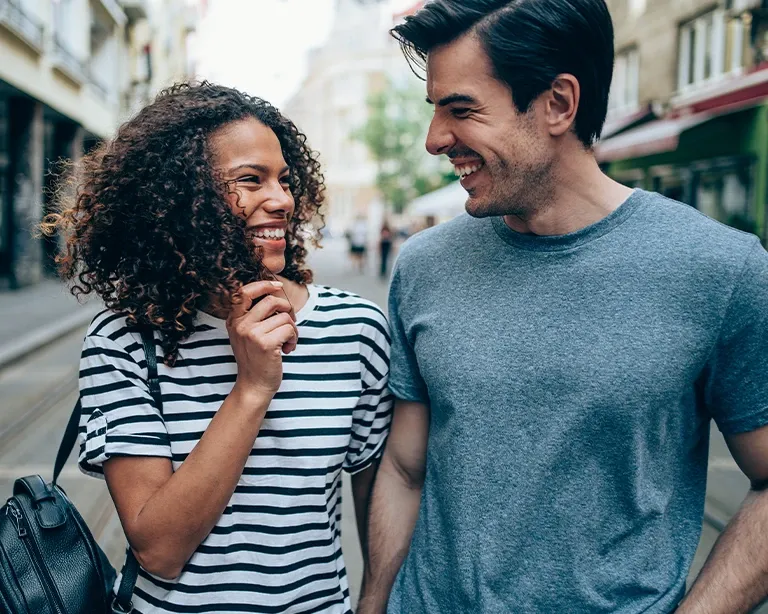 Two friends smiling while walking together