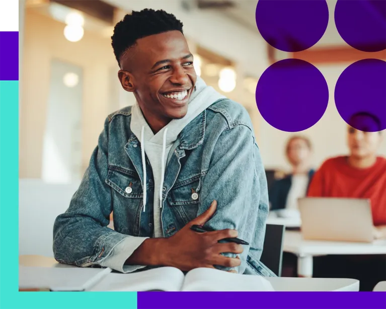 Young man smiling during an IELTS classroom session.