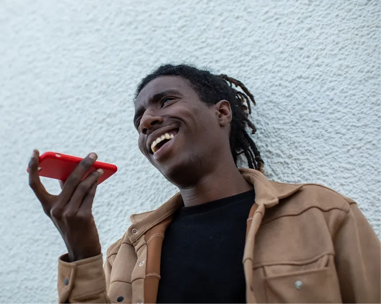 Young man using voice messaging on his mobile phone outdoors.