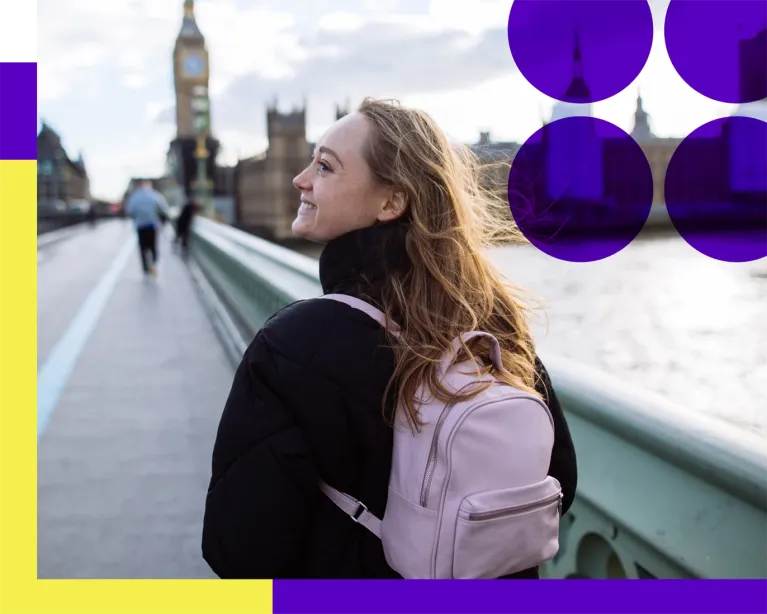 Young woman with a backpack enjoying a scenic waterfront city view while pursuing her study abroad journey.