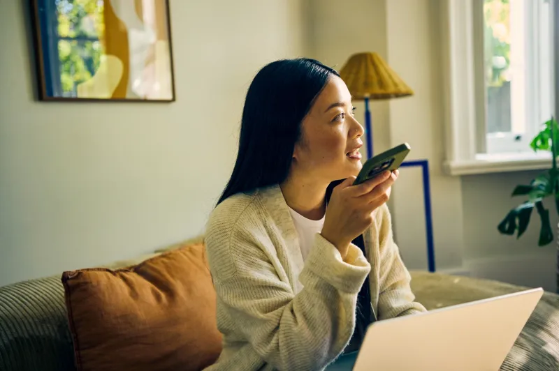 Young woman practicing for the IELTS listening test using voice messages at home.