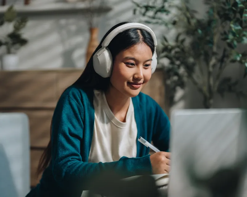 girl-studying-for-ielts-with-headphones-and-laptop