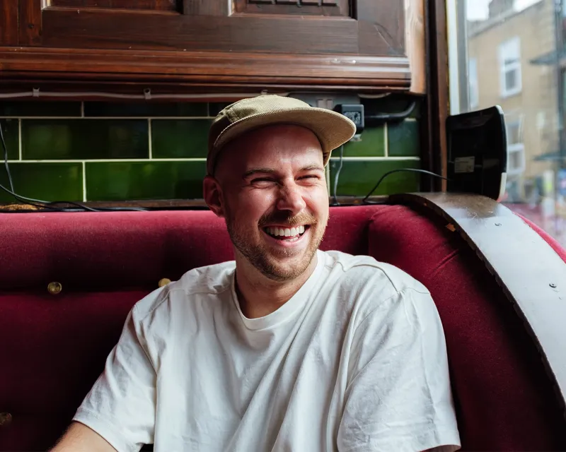smiling-man-cafe-booth-window