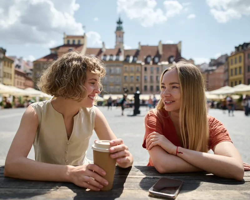 two-friends-talking-outdoor-cafe-european-city