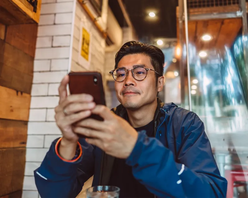 young-man-using-phone-cafe